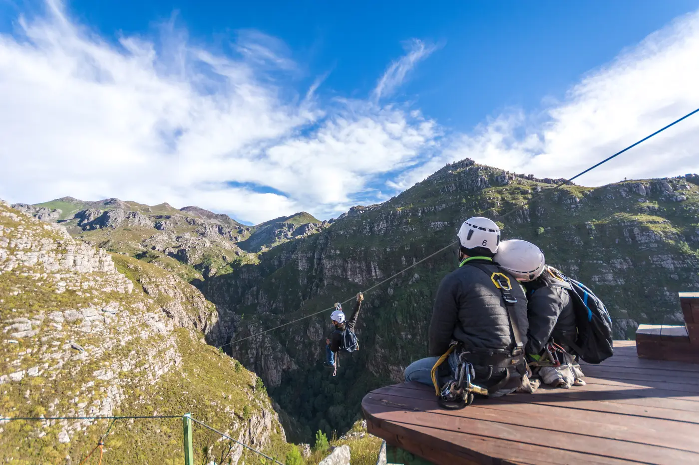 Two guests together on a zipline platform above the Elgin Valley gorge