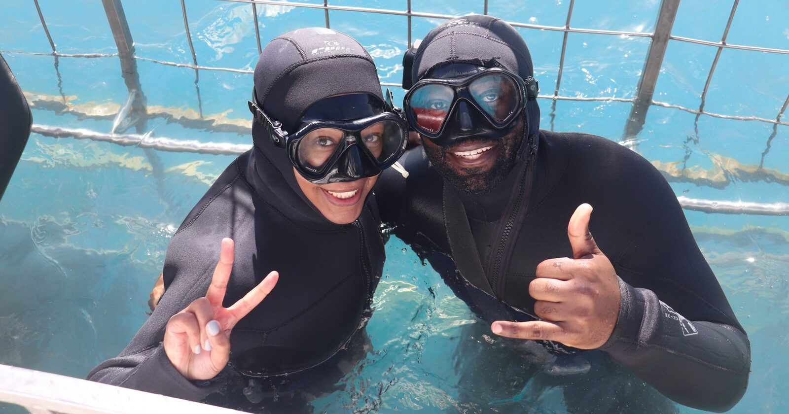 Guests smiling in the shark cage on a Marine Dynamics marine safari near Cape Town